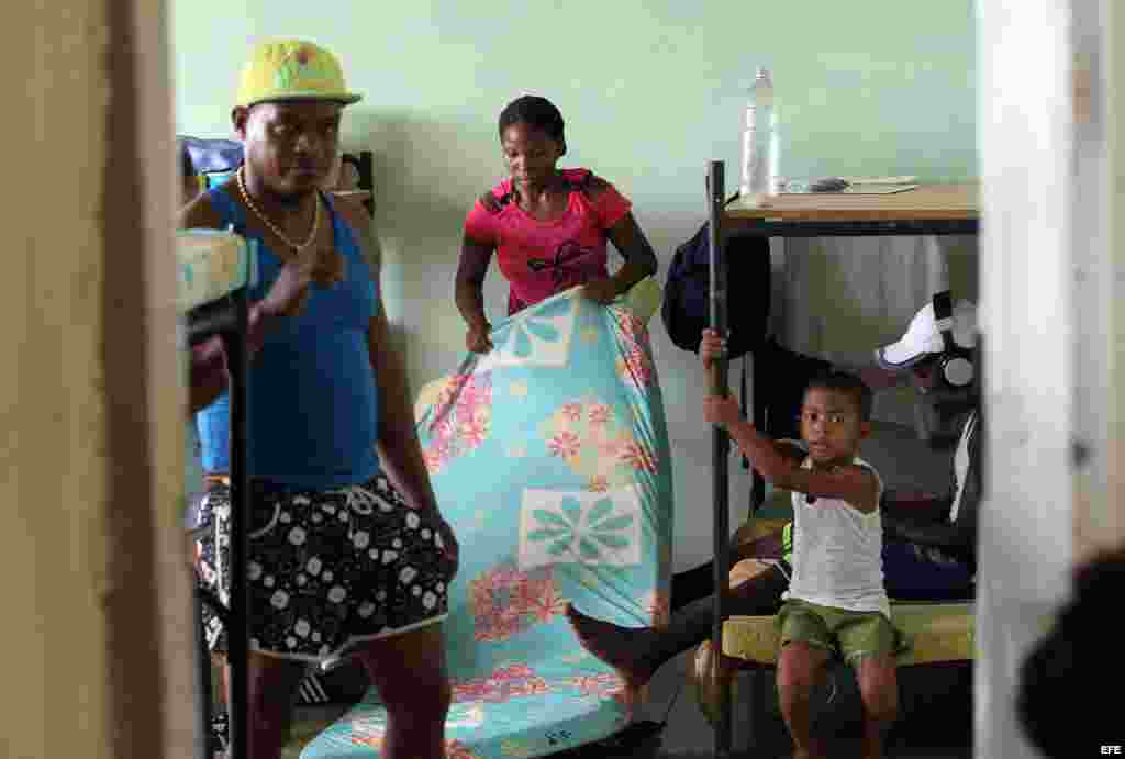 Una mujer acomoda sus pertenencias en un albergue organizado en una escuela hoy, lunes 03 de octubre de 2016, en la ciudad de Guantánamo (Cuba), ante la proximidad del huracán Matthew. Seis provincias de Cuba se encuentran bajo "alarma ciclónica" a la es