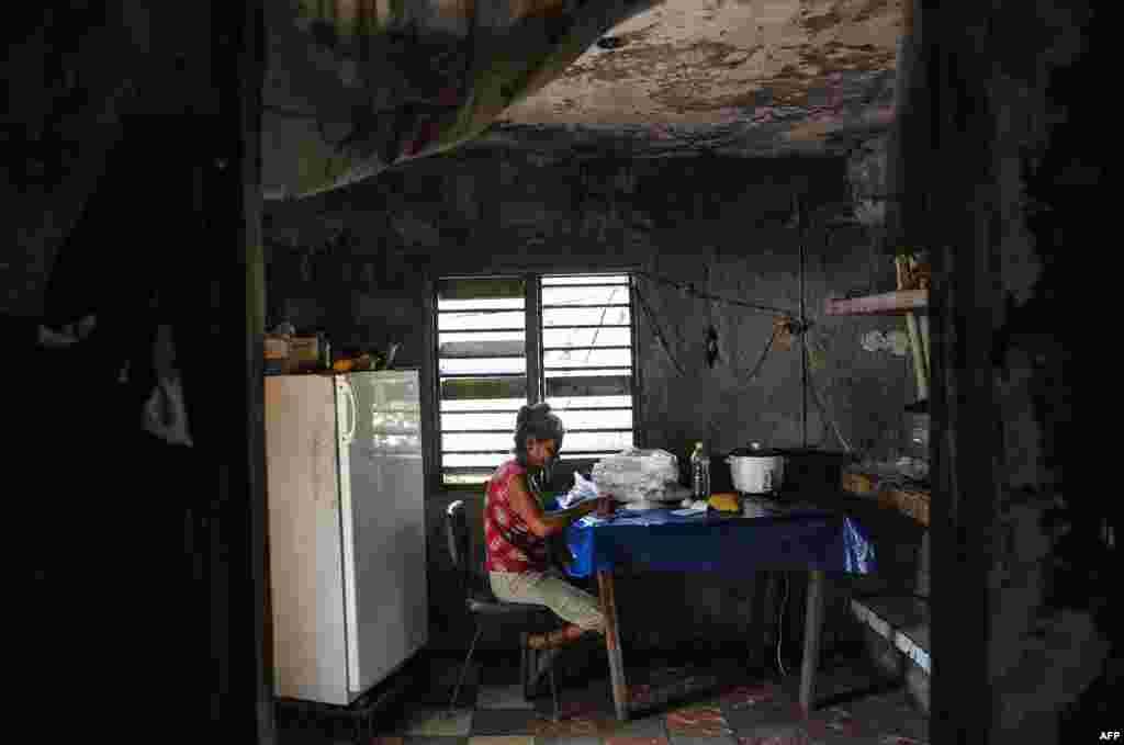 Una señora escoge arroz en su casa en El Caney, Santiago de Cuba el 21 de junio de 2017. Más de un 50% de los cubanos vive por debajo del umbral de pobreza. AFP PHOTO/YAMIL LAGE